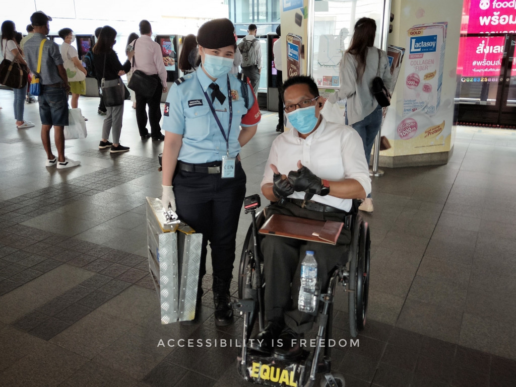 ภาพ พี่ซาบะถ่ายคู่กับ รปภ ที่กำลังถือทางลาดมาให้บริการขึ้นรถ